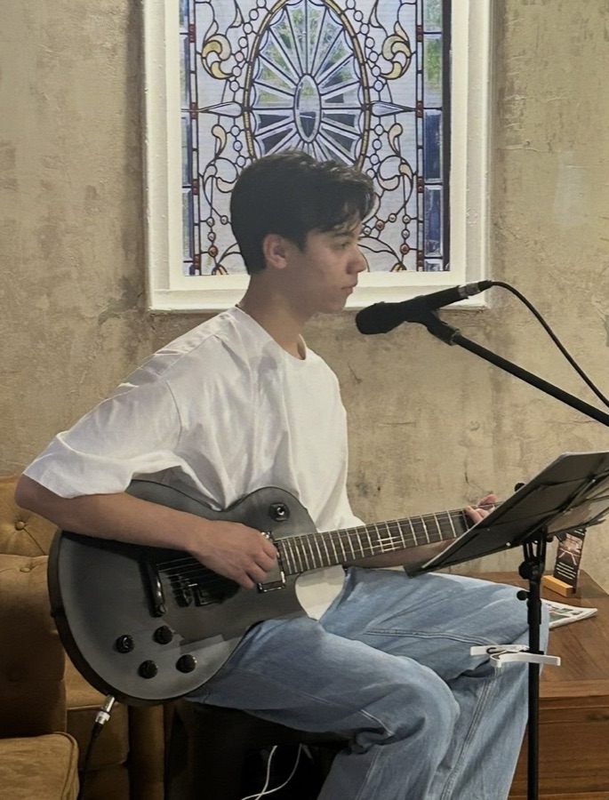 Liam performing live beneath the stained glass window at Henry's Bar and Restaurant